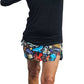 a woman in a black shirt and colorful shorts