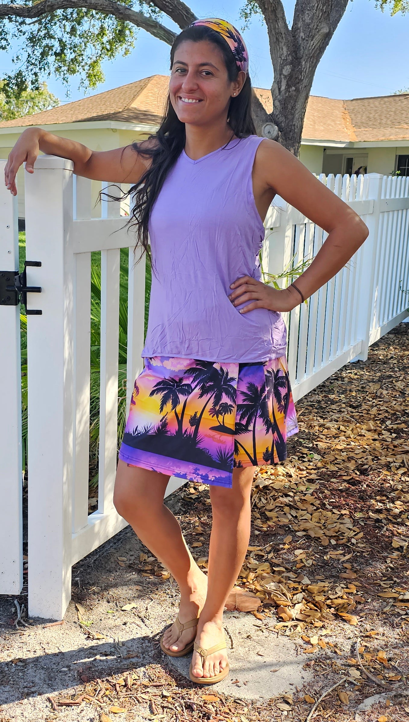 a woman standing in front of a white fence wearing a Lavender island wrap and matching bandana headband 