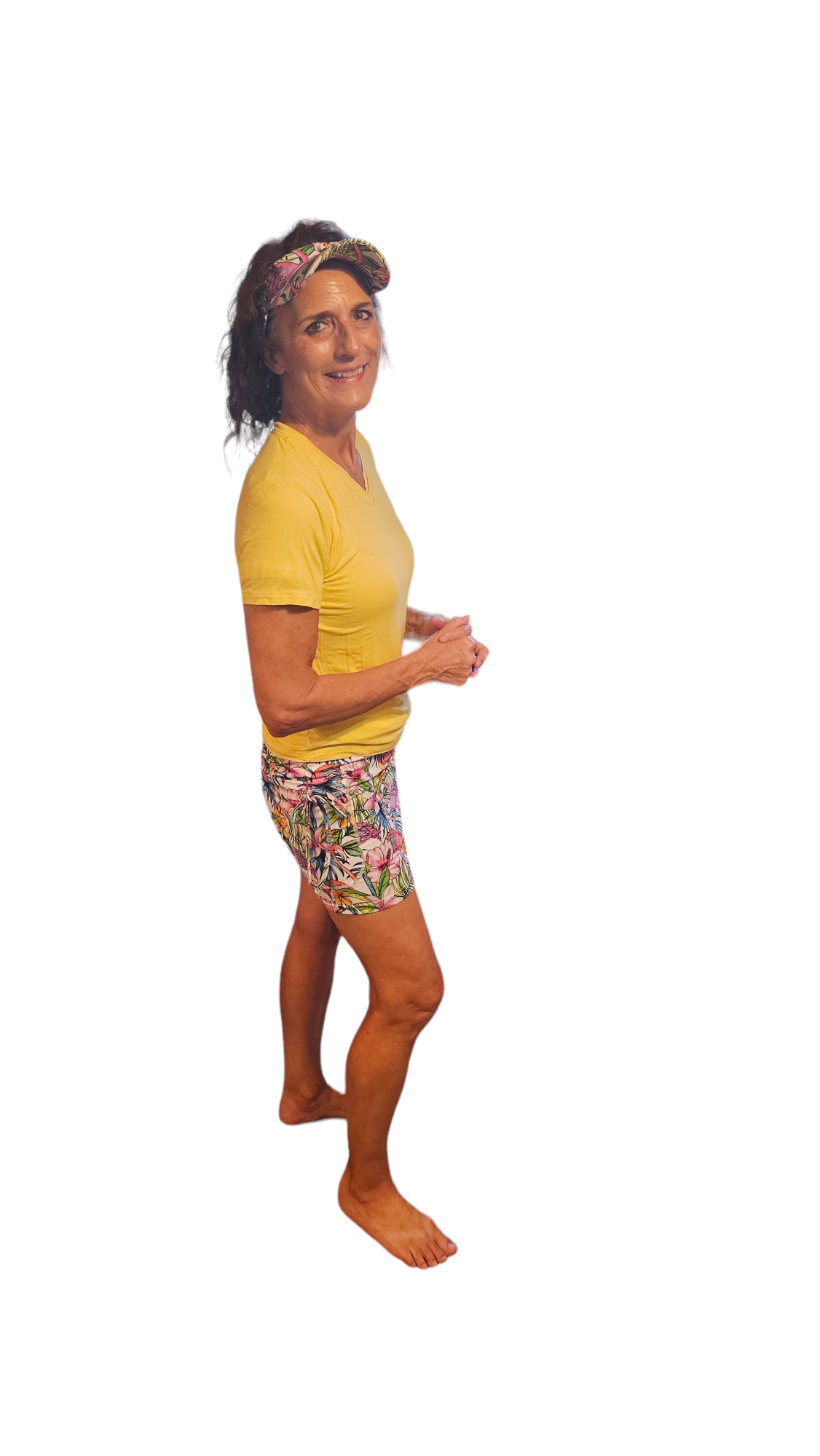 a woman in yellow shirt and shorts standing on one leg