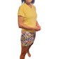 a woman in a yellow shirt and colorful shorts