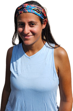 a woman in a blue tank top smiles at the camera wearing mandala headband 