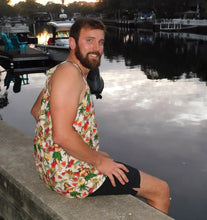 Load image into Gallery viewer, a man sitting on a ledge next to a body of water wearing a hula girl hawaiian design tank top 
